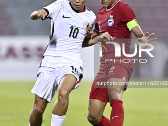 Raoul Suhaimi (R) of Singapore battles for the ball with Chiu Ching Yu Sergio (L) of Hong Kong, China, during the 2025 AFC U20 Asian Cup Qua...