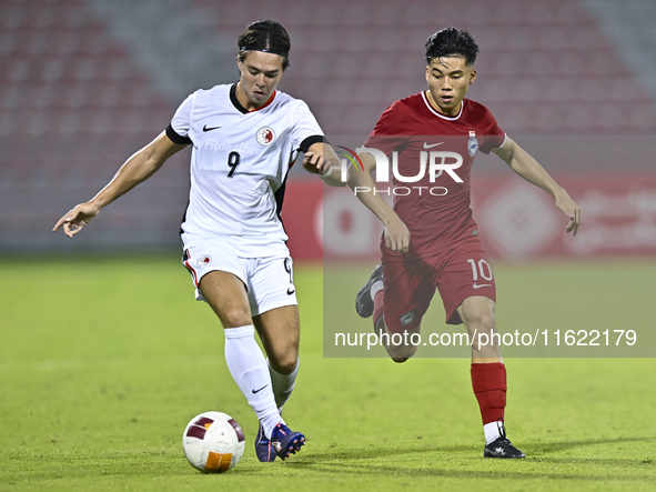 Jonan Tan (R) of Singapore battles for the ball with Matthew Luke Slattery (L) of Hong Kong, China, during the 2025 AFC U20 Asian Cup Qualif...