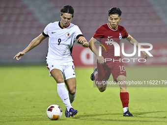 Jonan Tan (R) of Singapore battles for the ball with Matthew Luke Slattery (L) of Hong Kong, China, during the 2025 AFC U20 Asian Cup Qualif...