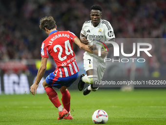 Vinicius Junior left winger of Real Madrid and Brazil and Robin Le Normand centre-back of Atletico de Madrid and Spaincompete for the ball d...