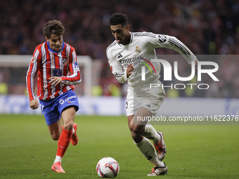 Jude Bellingham of Real Madrid and Rodrigo Riquelme of Atletico de Madrid fight for the ball during the La Liga 2024/25 match between Atleti...