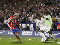 Vinicius Jr of Real Madrid and Rodrigo De Paul of Atletico de Madrid fight for the ball during the La Liga 2024/25 match between Atletico de...