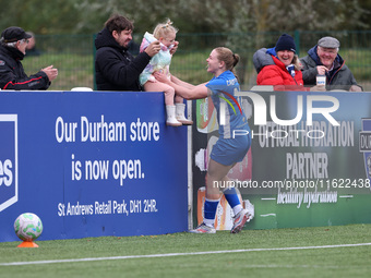 Lily Crosthwaite of Durham Women celebrates with a child spectator after scoring their first goal during the FA Women's Championship match b...