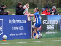 Lily Crosthwaite of Durham Women celebrates with a child spectator after scoring their first goal during the FA Women's Championship match b...