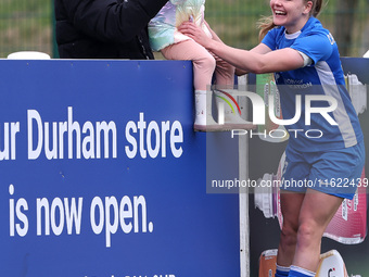 Lily Crosthwaite of Durham Women celebrates with a child spectator after scoring their first goal during the FA Women's Championship match b...