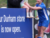 Lily Crosthwaite of Durham Women celebrates with a child spectator after scoring their first goal during the FA Women's Championship match b...