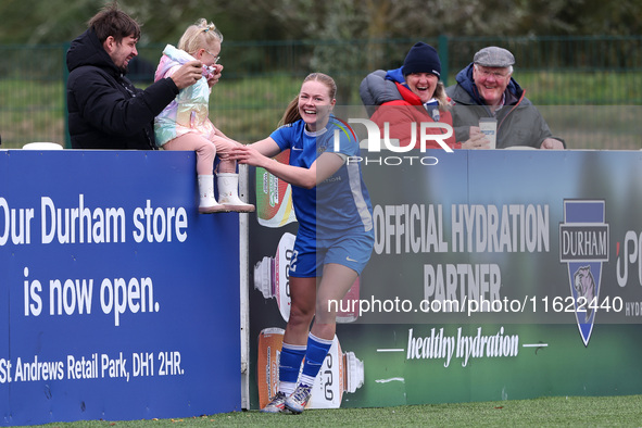 Lily Crosthwaite of Durham Women celebrates with a child spectator after scoring their first goal during the FA Women's Championship match b...