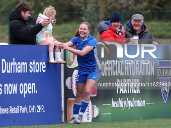 Lily Crosthwaite of Durham Women celebrates with a child spectator after scoring their first goal during the FA Women's Championship match b...