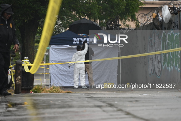 Crime scene investigators use evidence markers to mark the scene where a 29-year-old man is fatally shot in the head at East 182nd Street an...