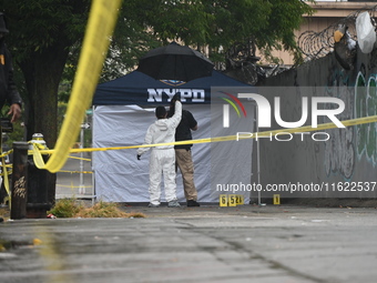 Crime scene investigators use evidence markers to mark the scene where a 29-year-old man is fatally shot in the head at East 182nd Street an...