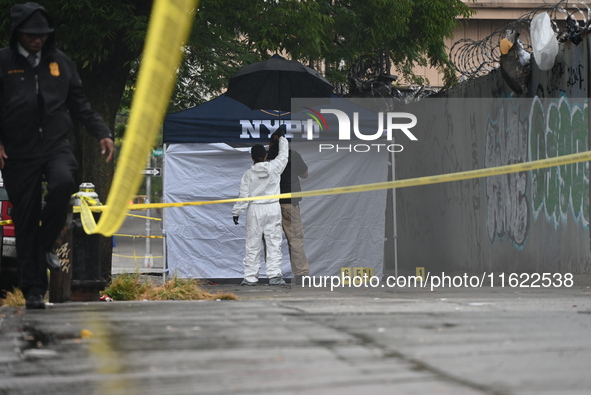 Crime scene investigators use evidence markers to mark the scene where a 29-year-old man is fatally shot in the head at East 182nd Street an...