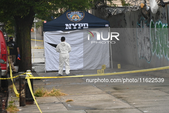 Crime scene investigators use evidence markers to mark the scene where a 29-year-old man is fatally shot in the head at East 182nd Street an...