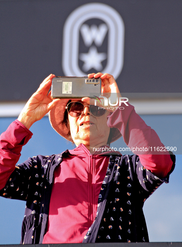 A race fan videotapes the post parade ahead of a race at Woodbine Racetrack in Toronto, Canada, on September 29, 2024. 