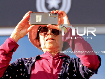 A race fan videotapes the post parade ahead of a race at Woodbine Racetrack in Toronto, Canada, on September 29, 2024. (