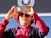 A race fan videotapes the post parade ahead of a race at Woodbine Racetrack in Toronto, Canada, on September 29, 2024. (