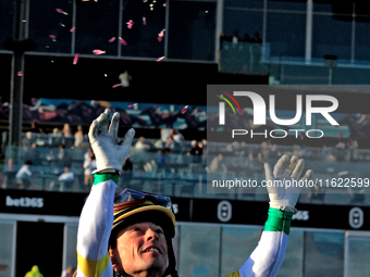 Jockey Justin Stein tosses flowers from a garland after a win in the 134th running of the $400,000 Breeders' Stakes, the third race of the O...