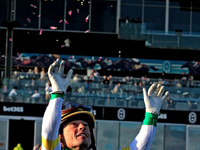 Jockey Justin Stein tosses flowers from a garland after a win in the 134th running of the $400,000 Breeders' Stakes, the third race of the O...