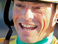 Jockey Justin Stein laughs while celebrating in the winner's circle after riding Roscar to a win in the 134th running of the $400,000 Breede...