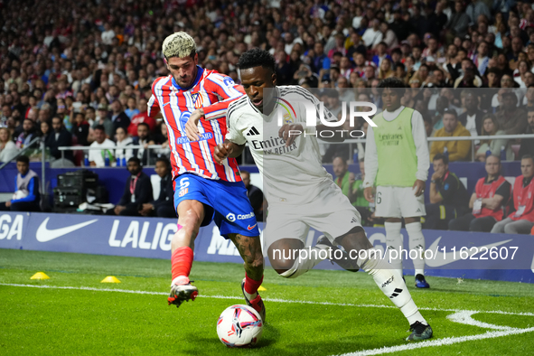 Vinicius Junior left winger of Real Madrid and Brazil and Rodrigo de Paul central midfield of Atletico de Madrid and Argentina compete for t...