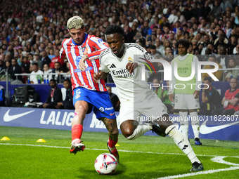 Vinicius Junior left winger of Real Madrid and Brazil and Rodrigo de Paul central midfield of Atletico de Madrid and Argentina compete for t...