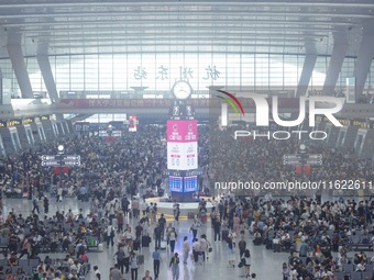 Passengers wait at the waiting hall of Hangzhou East Railway Station in Hangzhou, China, on September 30, 2024. On the day before the Nation...