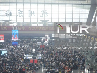 Passengers wait at the waiting hall of Hangzhou East Railway Station in Hangzhou, China, on September 30, 2024. On the day before the Nation...