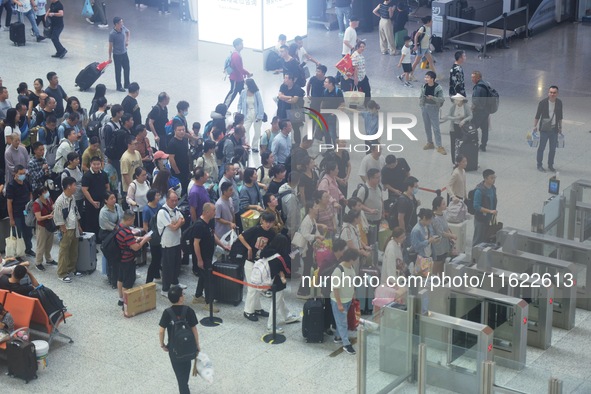 Passengers wait at the waiting hall of Hangzhou East Railway Station in Hangzhou, China, on September 30, 2024. On the day before the Nation...