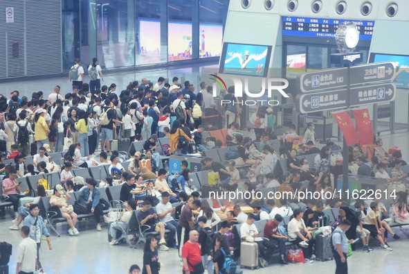 Passengers wait at the waiting hall of Hangzhou East Railway Station in Hangzhou, China, on September 30, 2024. On the day before the Nation...