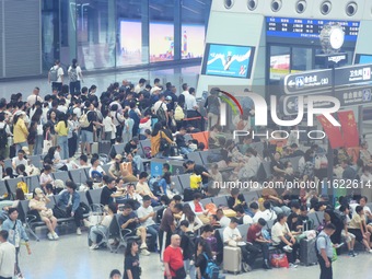 Passengers wait at the waiting hall of Hangzhou East Railway Station in Hangzhou, China, on September 30, 2024. On the day before the Nation...