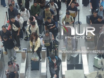 Passengers wait at the waiting hall of Hangzhou East Railway Station in Hangzhou, China, on September 30, 2024. On the day before the Nation...