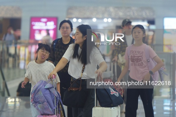 Passengers wait at the waiting hall of Hangzhou East Railway Station in Hangzhou, China, on September 30, 2024. On the day before the Nation...