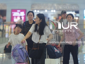 Passengers wait at the waiting hall of Hangzhou East Railway Station in Hangzhou, China, on September 30, 2024. On the day before the Nation...