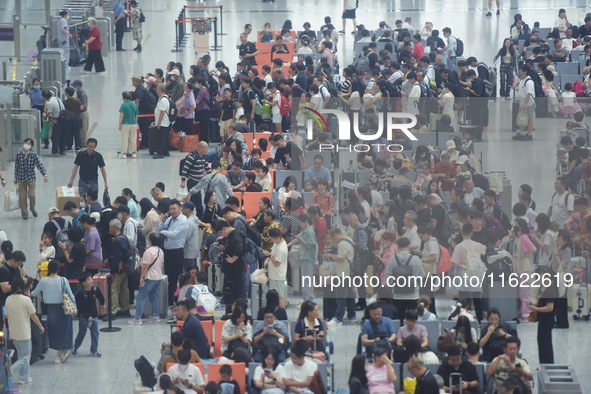 Passengers wait at the waiting hall of Hangzhou East Railway Station in Hangzhou, China, on September 30, 2024. On the day before the Nation...