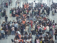 Passengers wait at the waiting hall of Hangzhou East Railway Station in Hangzhou, China, on September 30, 2024. On the day before the Nation...