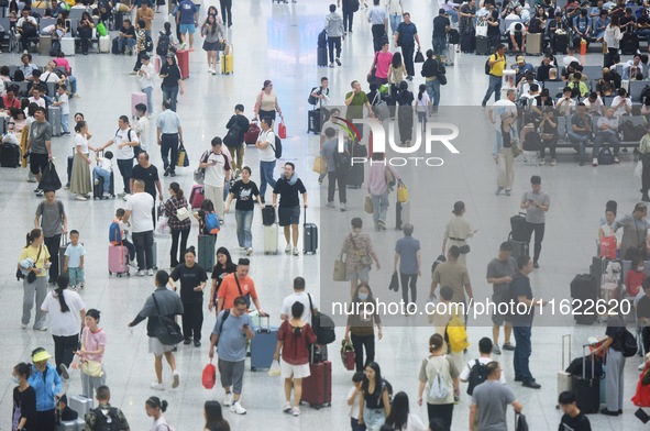 Passengers wait at the waiting hall of Hangzhou East Railway Station in Hangzhou, China, on September 30, 2024. On the day before the Nation...