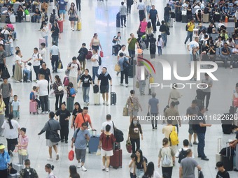 Passengers wait at the waiting hall of Hangzhou East Railway Station in Hangzhou, China, on September 30, 2024. On the day before the Nation...