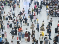 Passengers wait at the waiting hall of Hangzhou East Railway Station in Hangzhou, China, on September 30, 2024. On the day before the Nation...