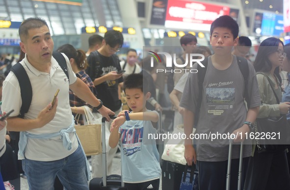 Passengers wait at the waiting hall of Hangzhou East Railway Station in Hangzhou, China, on September 30, 2024. On the day before the Nation...