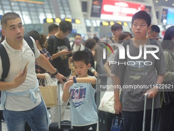 Passengers wait at the waiting hall of Hangzhou East Railway Station in Hangzhou, China, on September 30, 2024. On the day before the Nation...