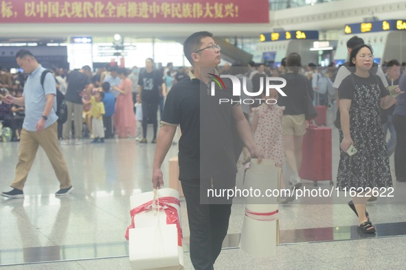 Passengers wait at the waiting hall of Hangzhou East Railway Station in Hangzhou, China, on September 30, 2024. On the day before the Nation...