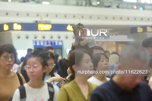 Passengers wait at the waiting hall of Hangzhou East Railway Station in Hangzhou, China, on September 30, 2024. On the day before the Nation...