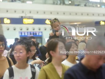 Passengers wait at the waiting hall of Hangzhou East Railway Station in Hangzhou, China, on September 30, 2024. On the day before the Nation...