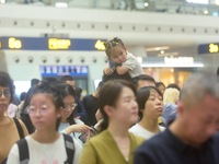 Passengers wait at the waiting hall of Hangzhou East Railway Station in Hangzhou, China, on September 30, 2024. On the day before the Nation...