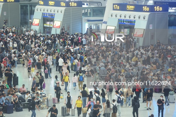 Passengers wait at the waiting hall of Hangzhou East Railway Station in Hangzhou, China, on September 30, 2024. On the day before the Nation...