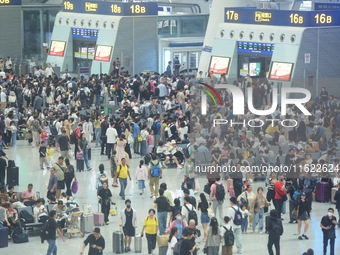 Passengers wait at the waiting hall of Hangzhou East Railway Station in Hangzhou, China, on September 30, 2024. On the day before the Nation...