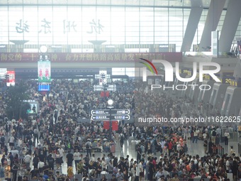 Passengers wait at the waiting hall of Hangzhou East Railway Station in Hangzhou, China, on September 30, 2024. On the day before the Nation...