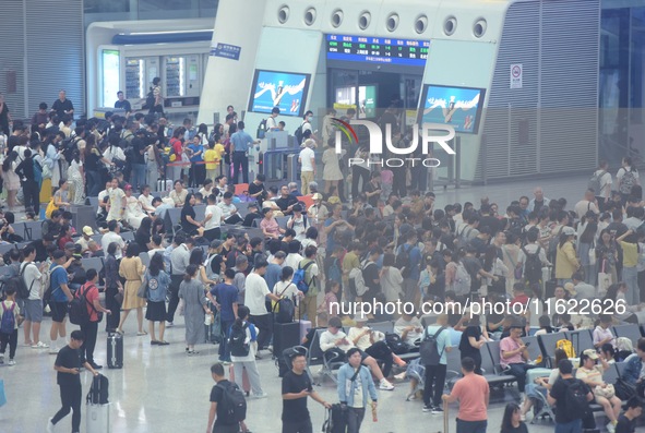 Passengers wait at the waiting hall of Hangzhou East Railway Station in Hangzhou, China, on September 30, 2024. On the day before the Nation...