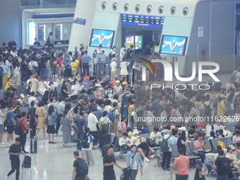 Passengers wait at the waiting hall of Hangzhou East Railway Station in Hangzhou, China, on September 30, 2024. On the day before the Nation...