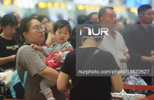 Passengers wait at the waiting hall of Hangzhou East Railway Station in Hangzhou, China, on September 30, 2024. On the day before the Nation...