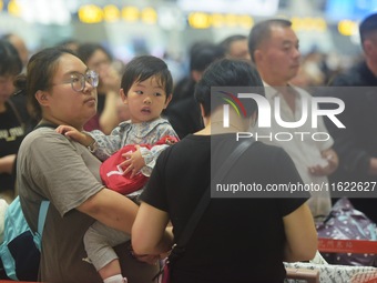 Passengers wait at the waiting hall of Hangzhou East Railway Station in Hangzhou, China, on September 30, 2024. On the day before the Nation...